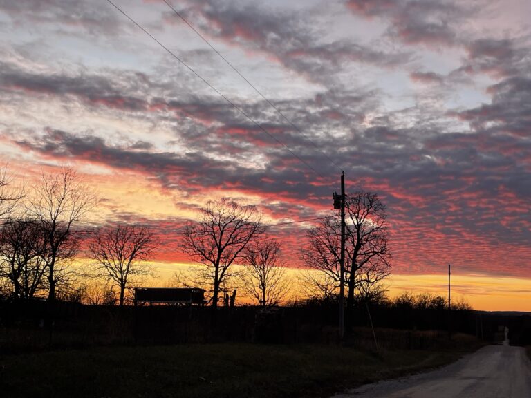 A beautiful sunset behind the dark silhouette of a sawmill and trees, representing the arrival of the Sabbath that comes like clockwork whether we’re ready or not.