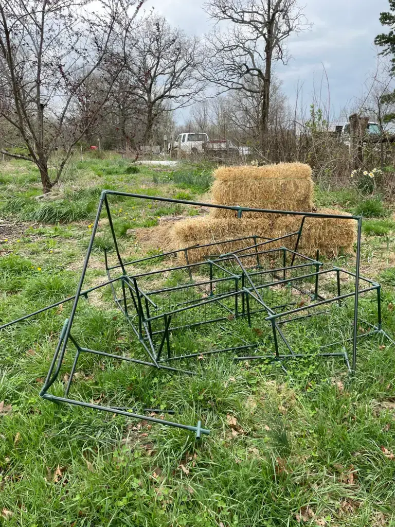 All that's left of a greenhouse is a pile of dark green piping and a few straw bales that once stabilized it.