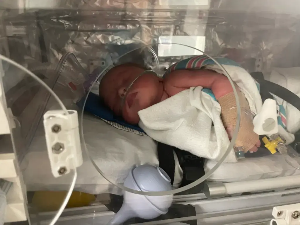 Too Late for the Hospital: My 37-Week Unplanned Home Birth and the Helicopter Ride to the NICU 8 Newborn Wrangler in transport incubator with the access window open.
