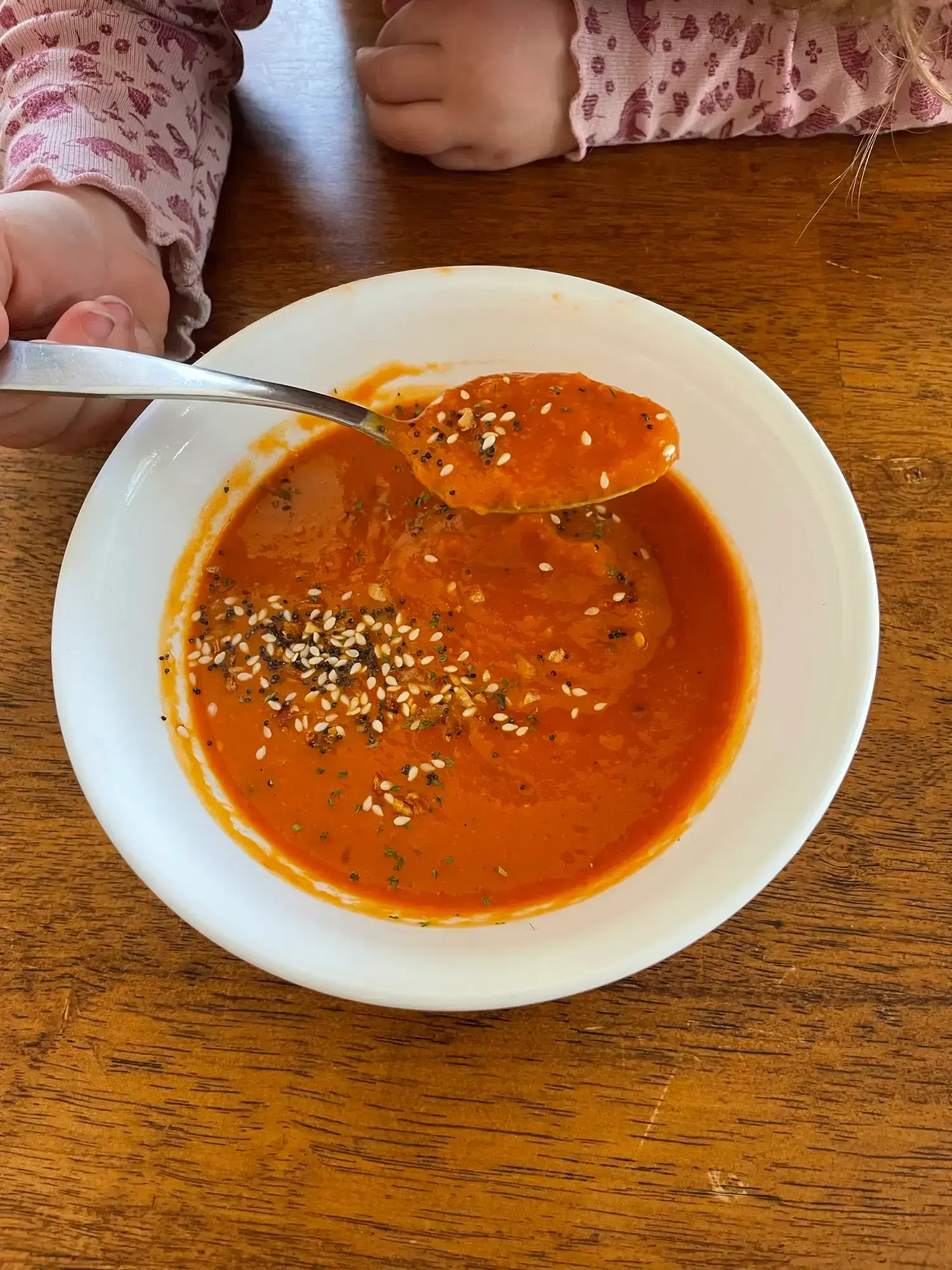 Homemade tomato soup, made with a simple formula, garnished with poppy and sesame seeds, ready to eat.
